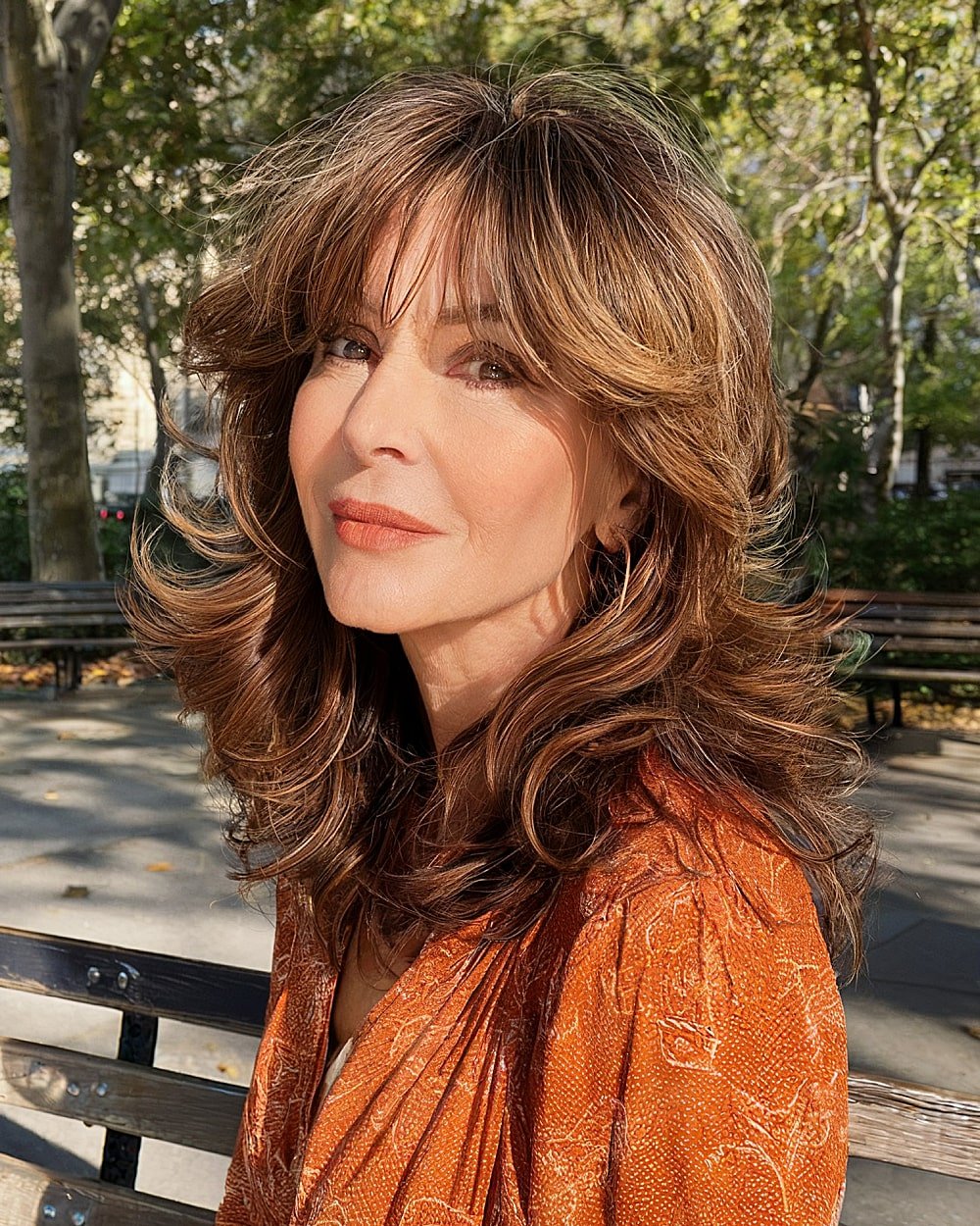 Modern 70s-inspired shag haircut with layered waves and soft bangs for women over 50