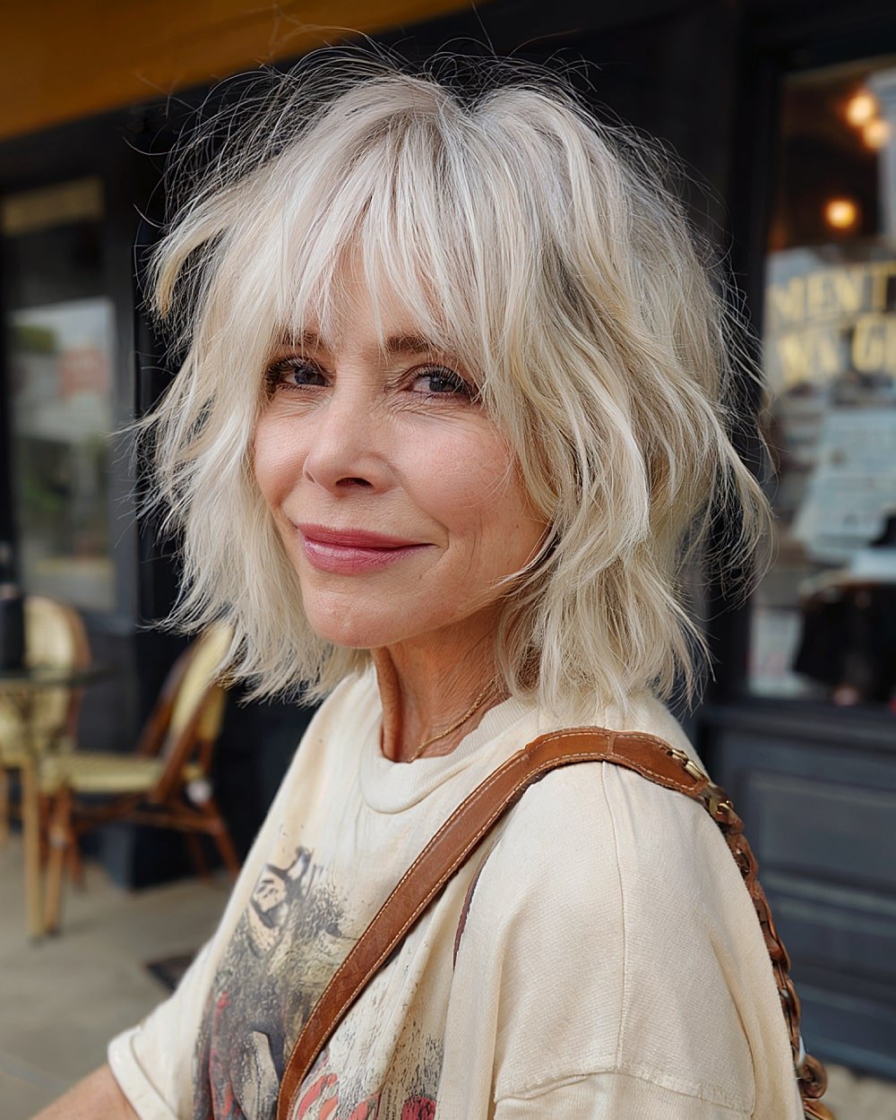90s-inspired shaggy haircut with feathered layers and wispy bangs for older women