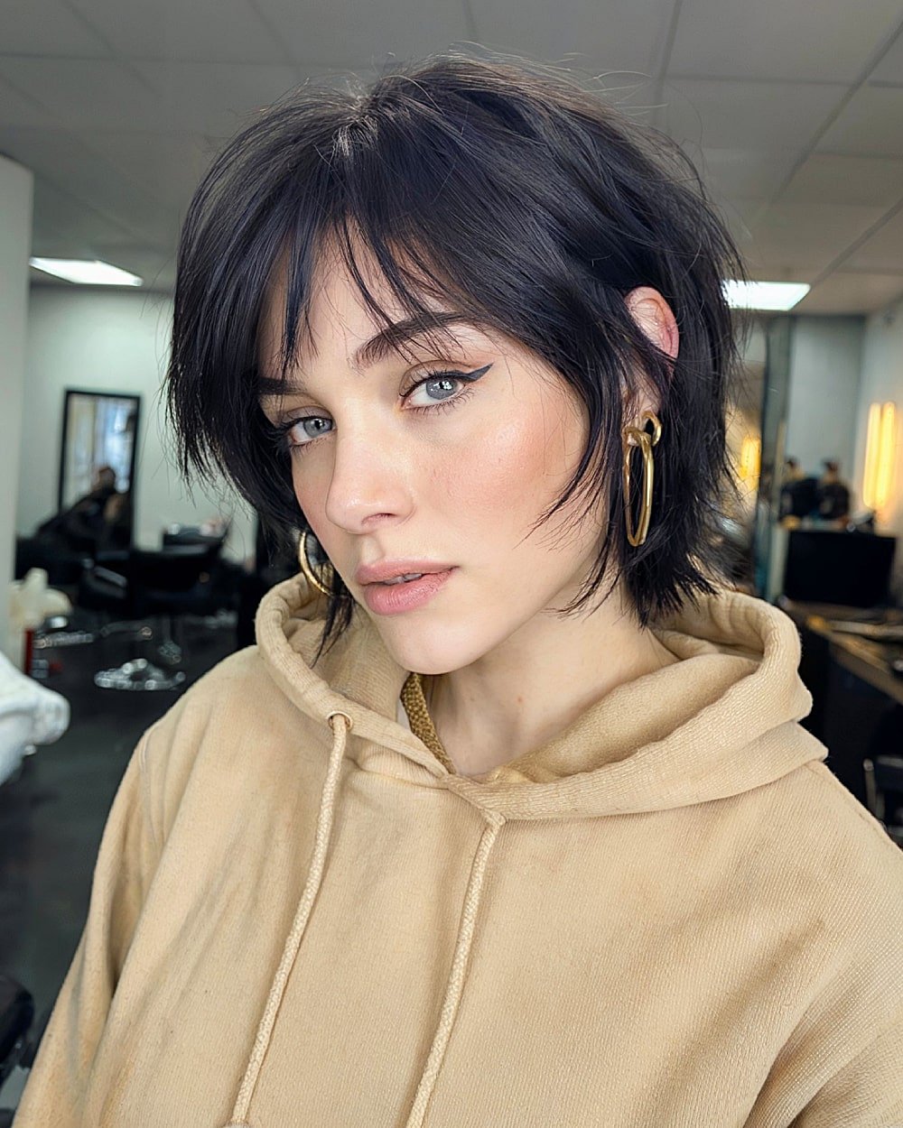 Edgy short layered haircut with jagged ends and textured bangs for a bold alt look