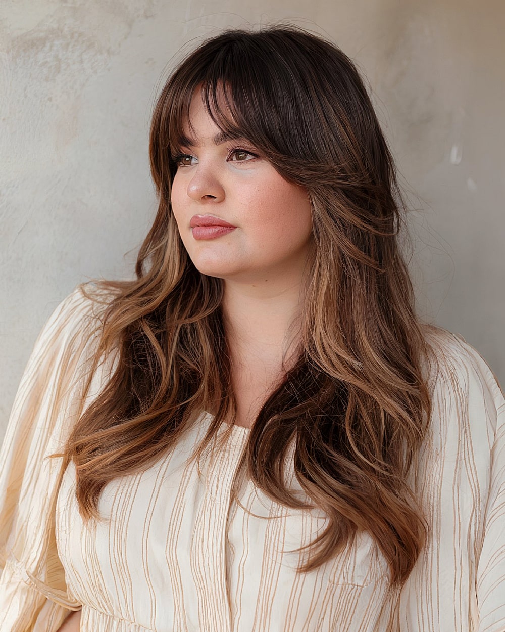 Butterfly haircut with airy curtain bangs on long brunette hair for round faces