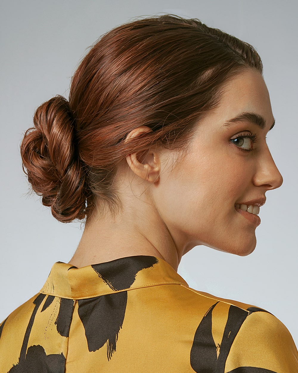 Chic French bun twist with low sleek finish for polished brunette hair