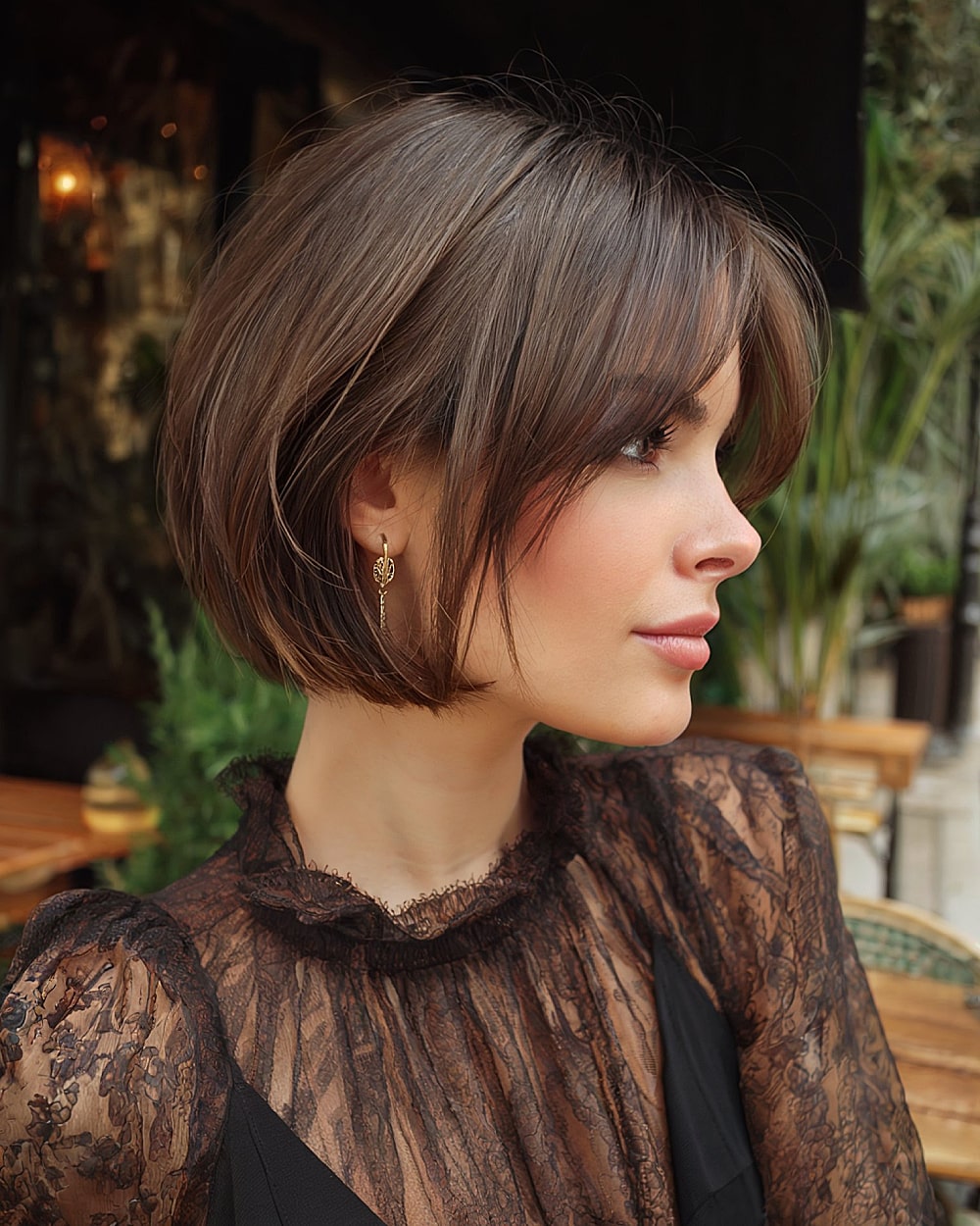 Polished pinch bob with curved under ends and soft forehead fringe on thick hair