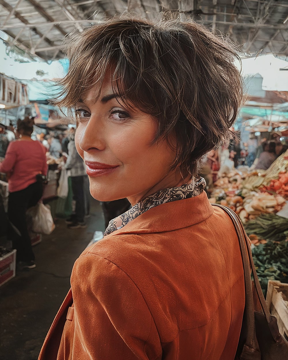 Tousled choppy pixie bob with layered ends and natural brunette tones for women over 40