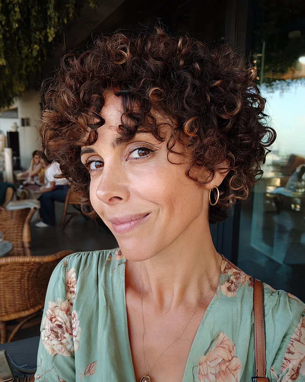 Short curly pixie bob with layered ringlets and defined shape for women over 40