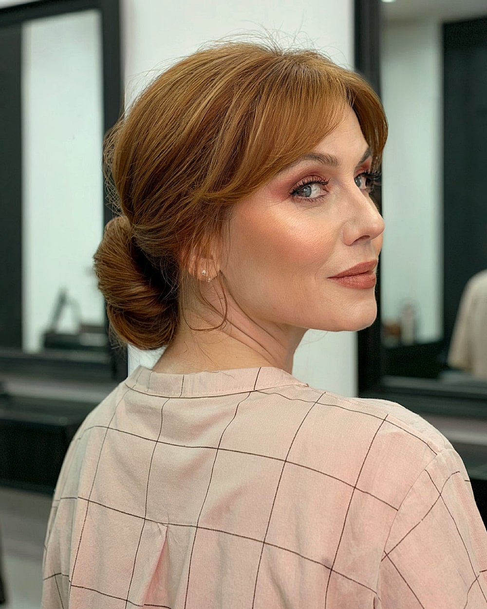 Simple French twist for medium length auburn hair with curtain bangs