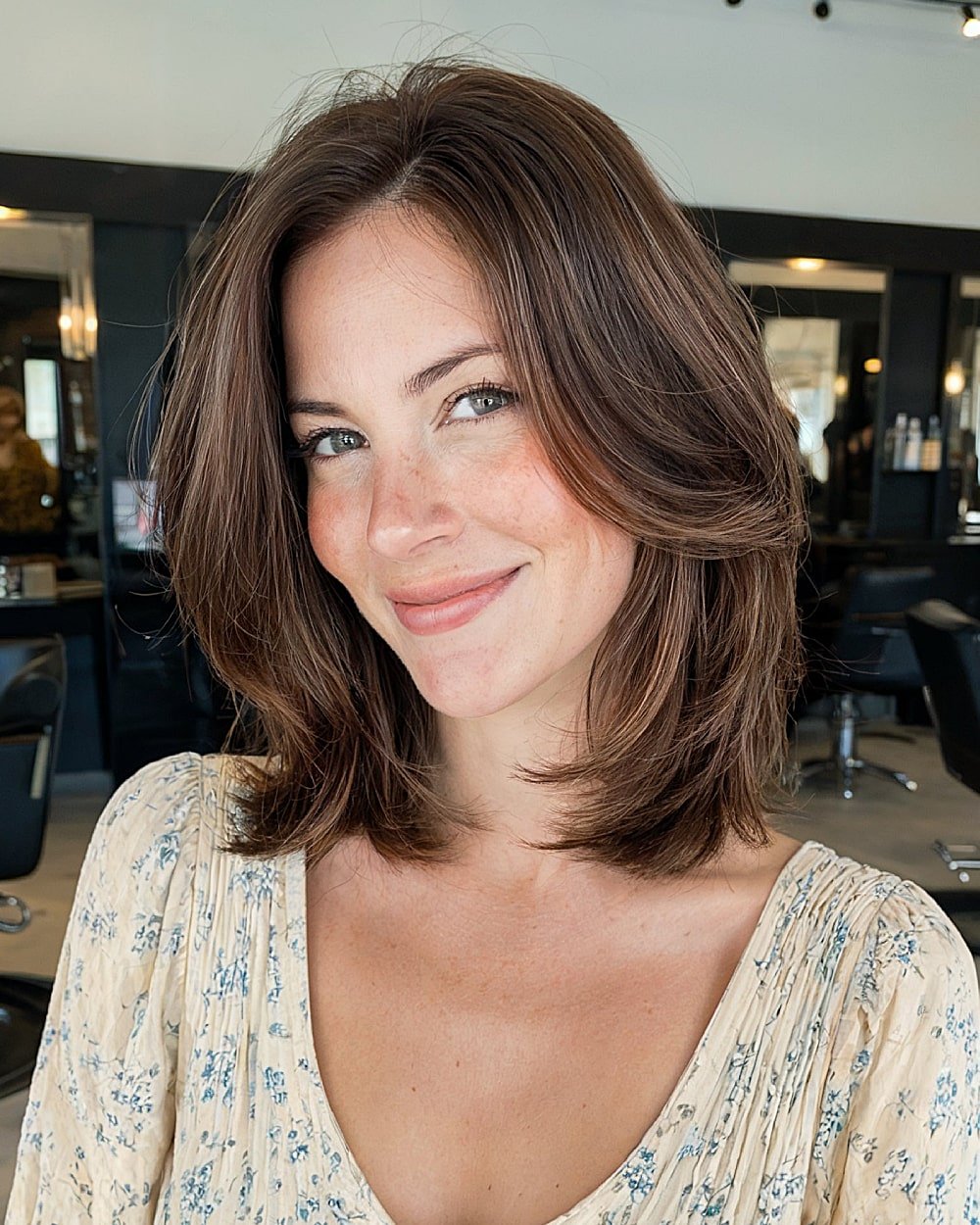 Shoulder-length feathered haircut with soft volume and rounded layering for alt layered hair