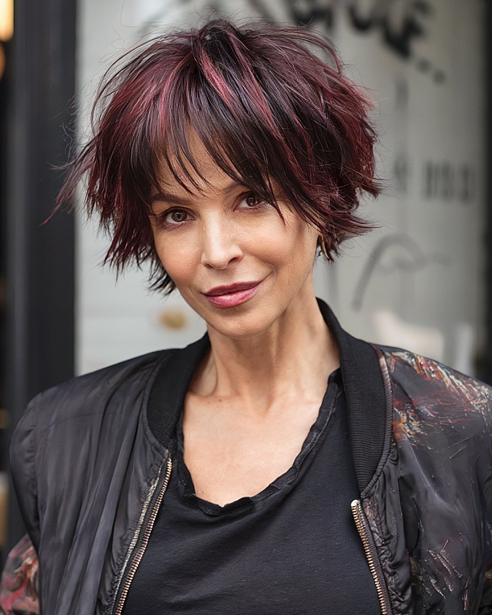 Funky pixie bob haircut with choppy layers and wine-red highlights for women over 40