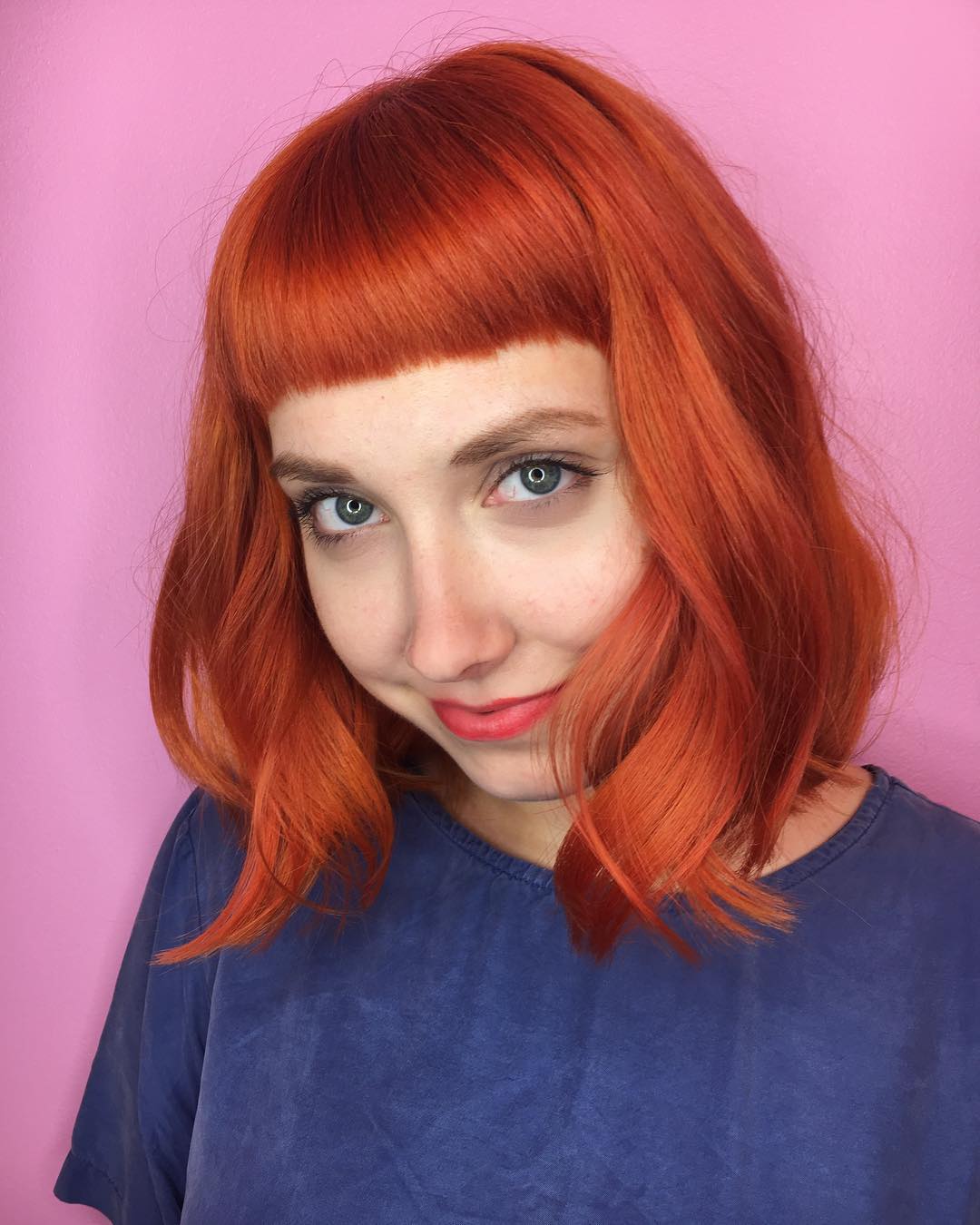 Bold Copper Wavy Bob with Chic Blunt Bangs