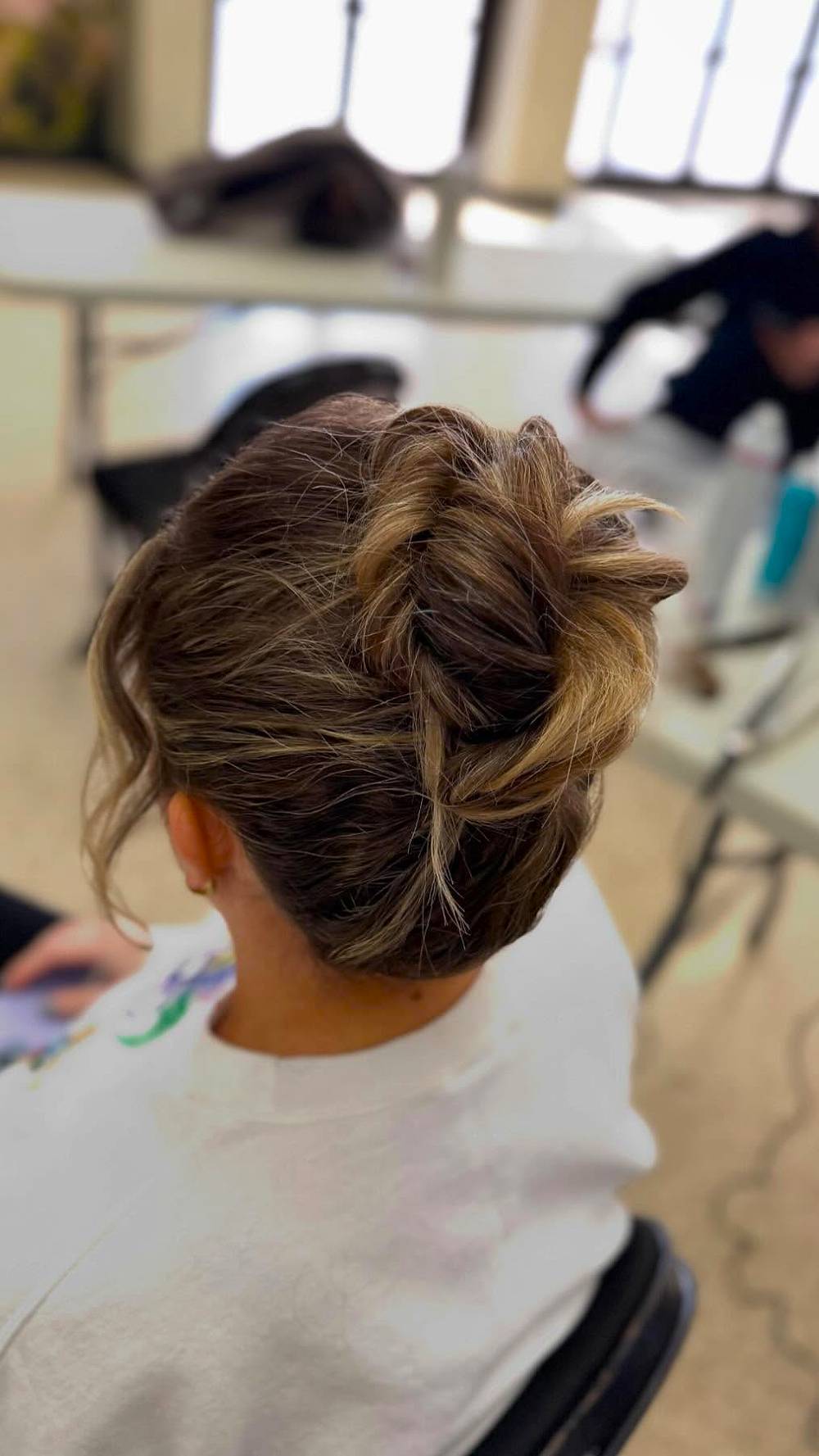 Textured High Bun with Loose Tendrils