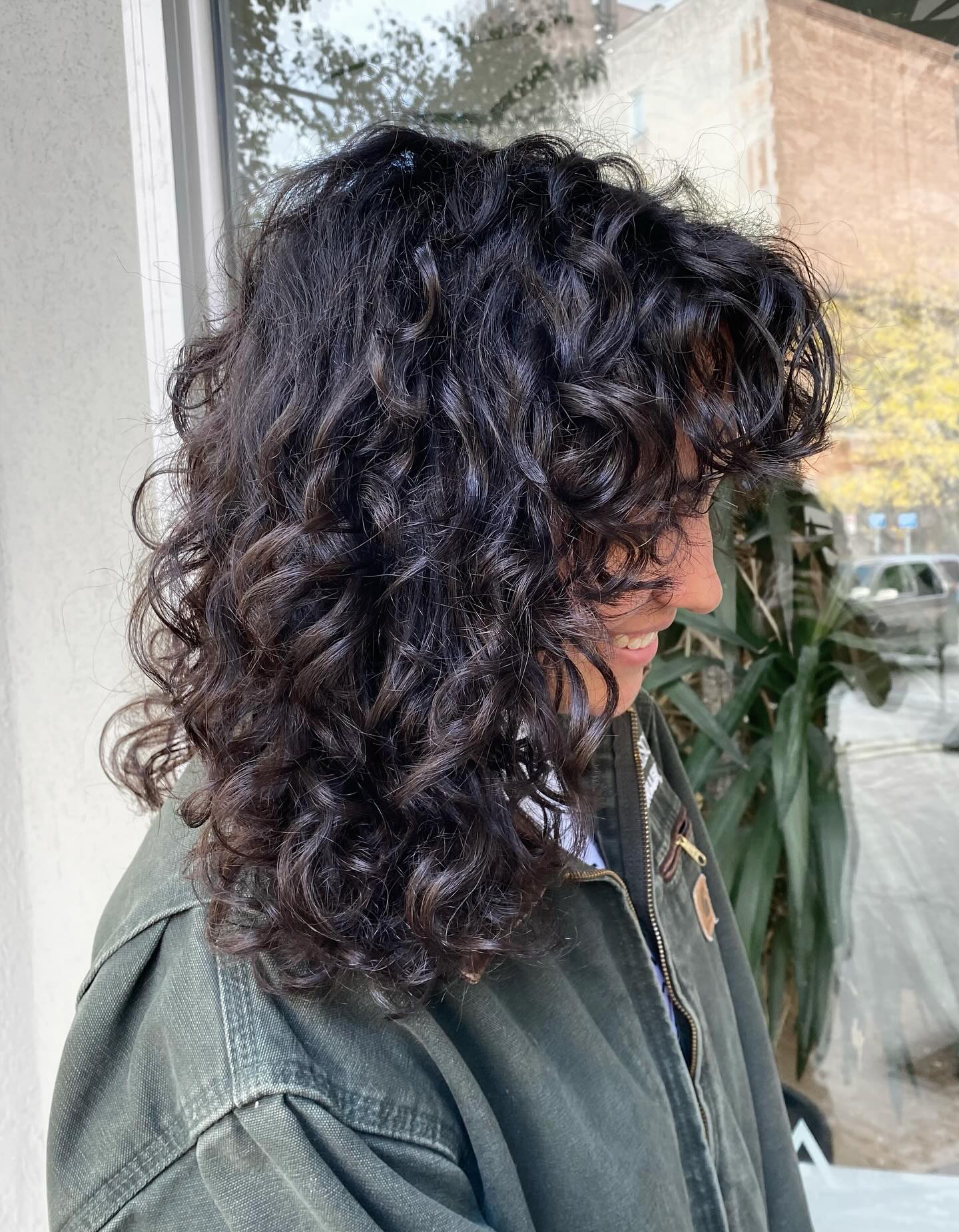 Wild and Textured Curly Wolf Cut with Playful Bangs