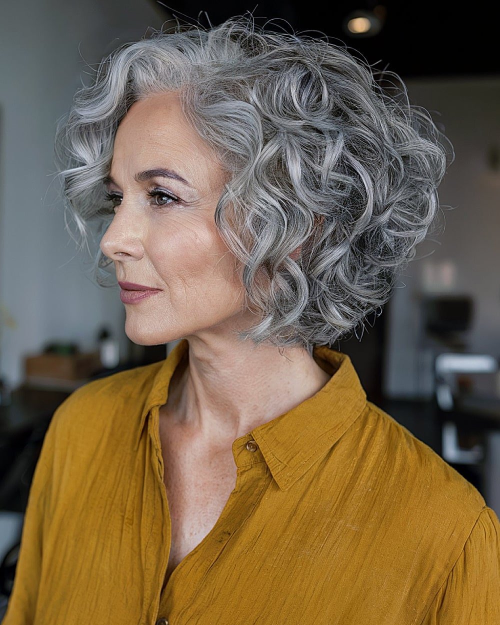 Silver-grey curly stacked bob haircut with rounded layers and airy volume