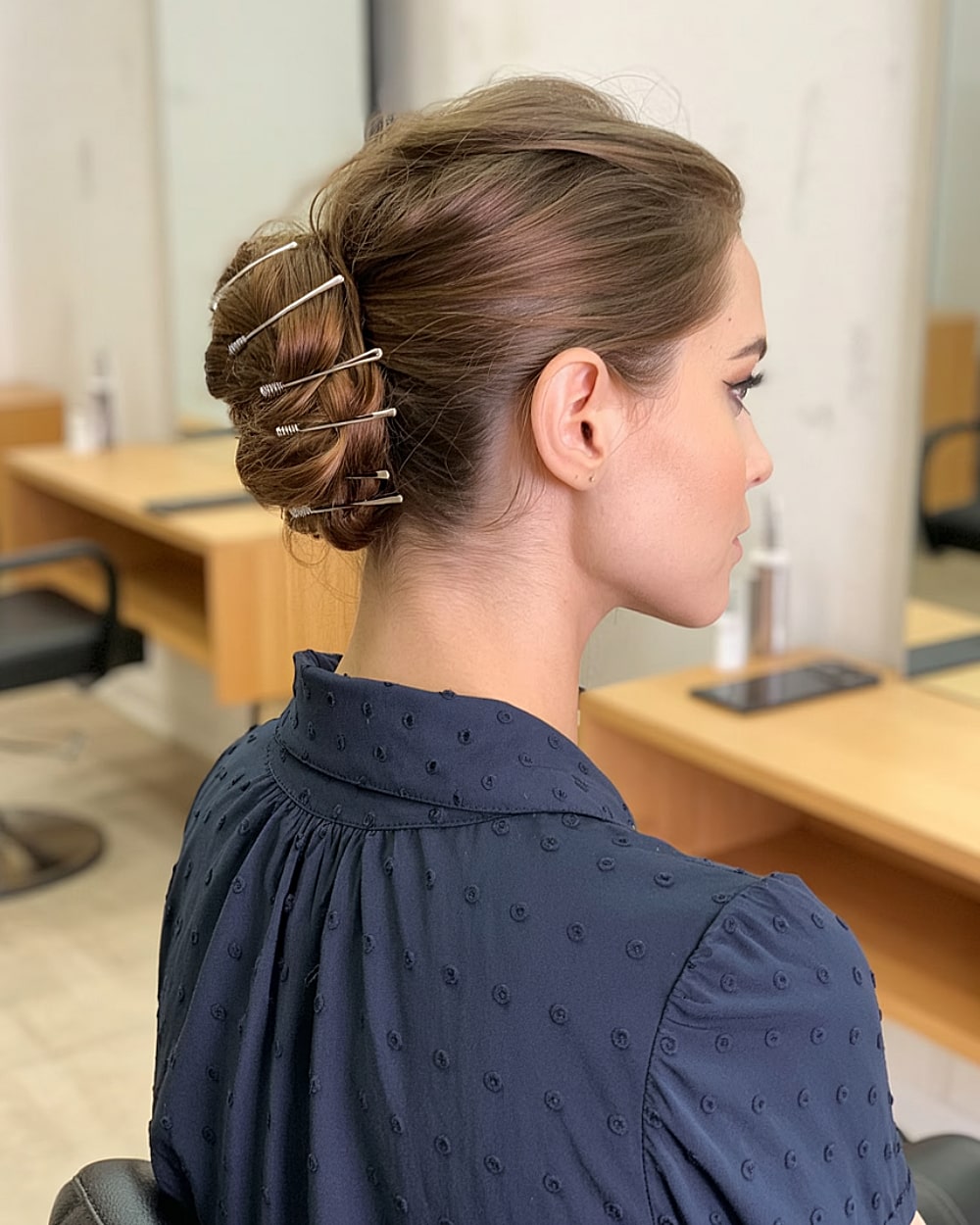 French twist with visible hair pins for edgy secured updo on brunette hair