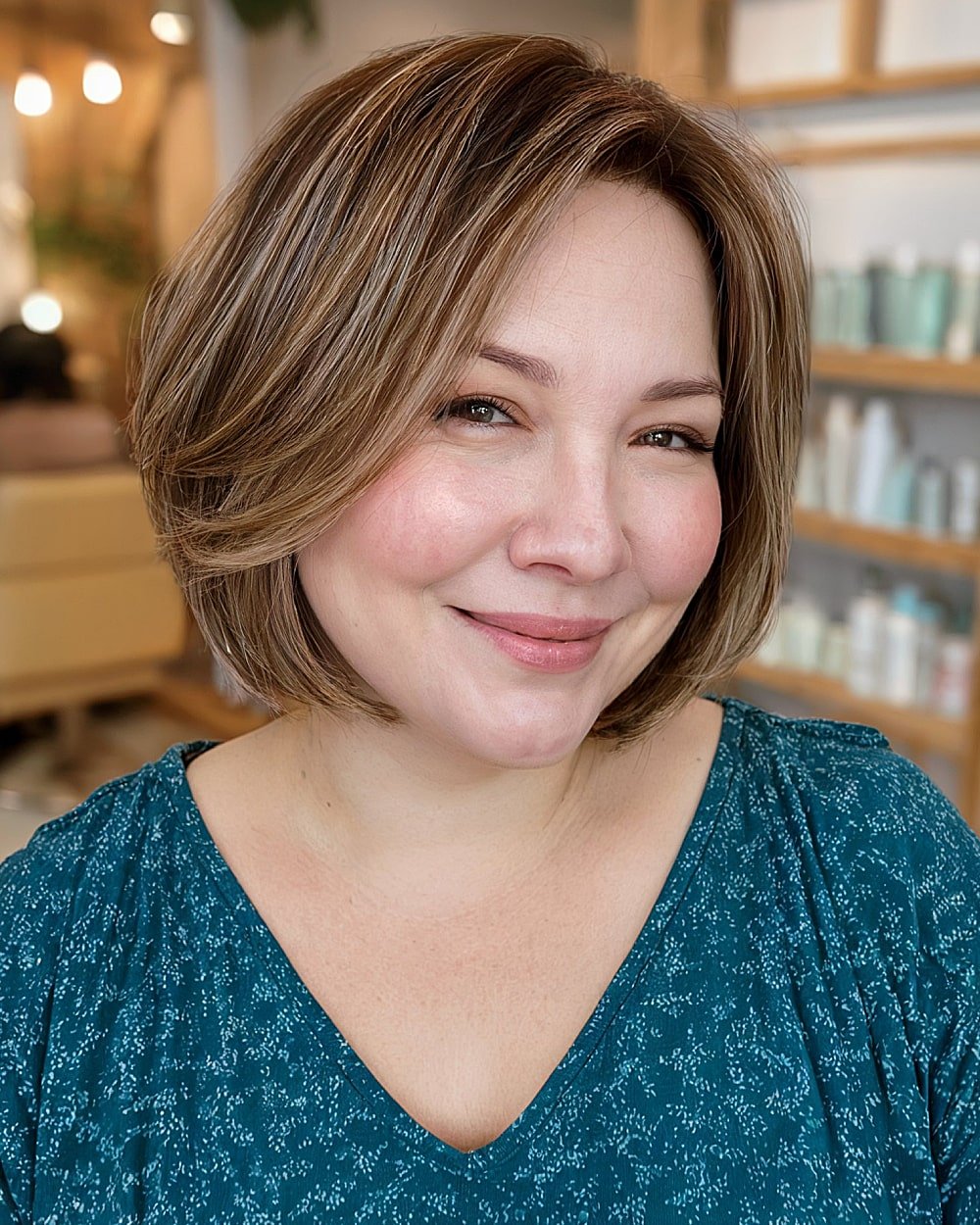 Layered bob haircut with side part and subtle highlights, flattering for round face shapes