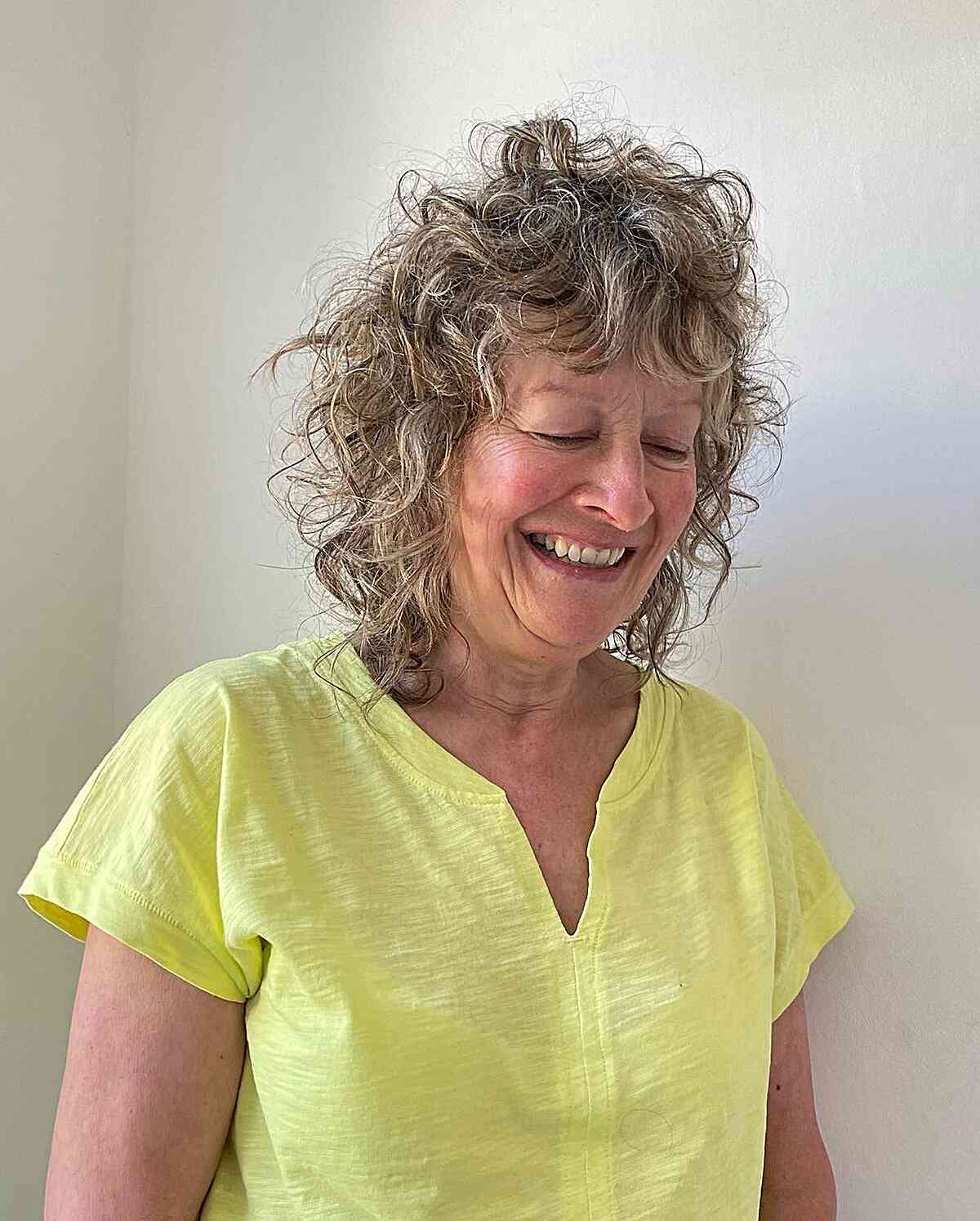 Medium Curly Cut with Feathered Bangs on Older Ladies Over Fifty