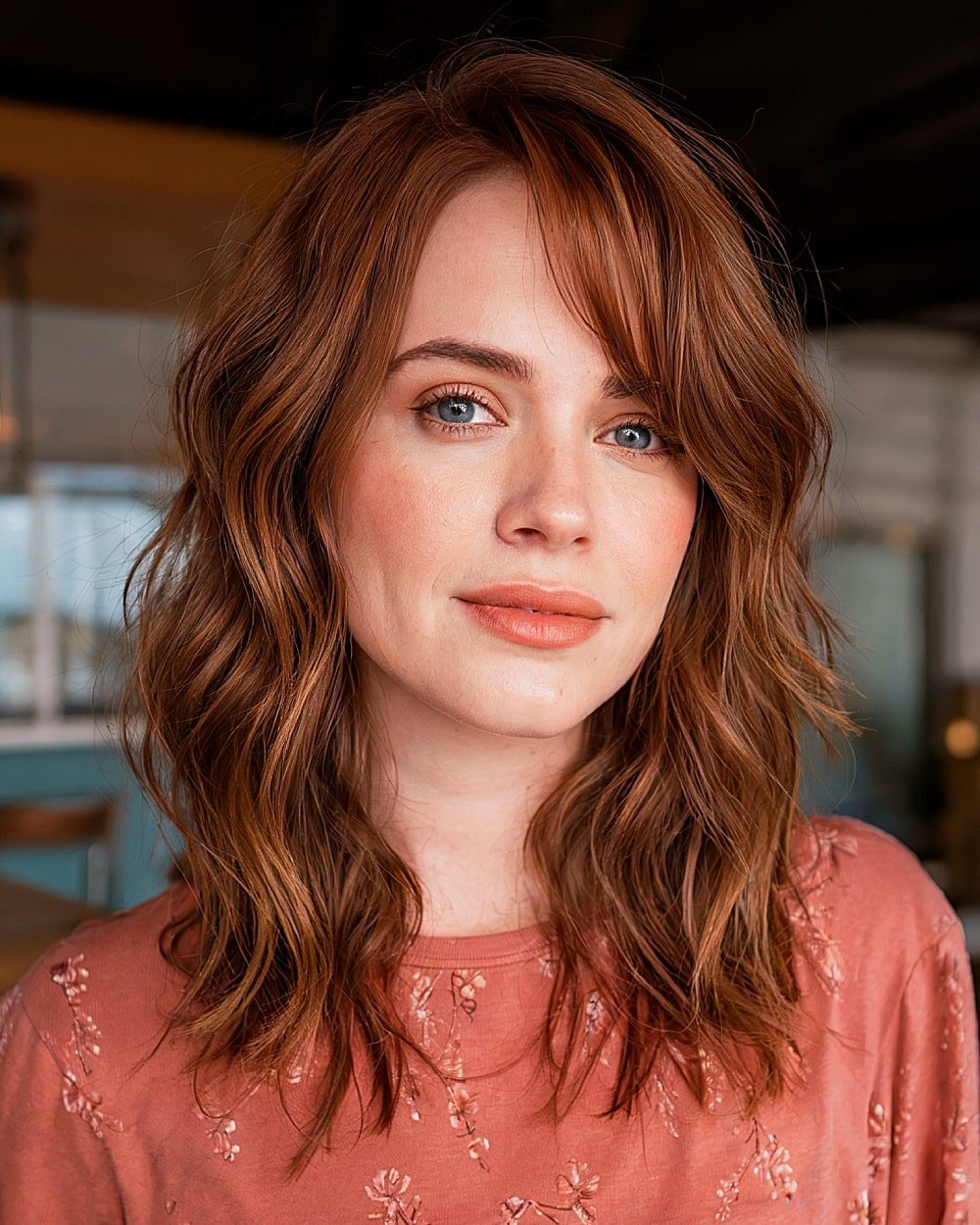 Medium-length layered haircut with soft beachy waves and side-swept bangs for an alt-inspired look