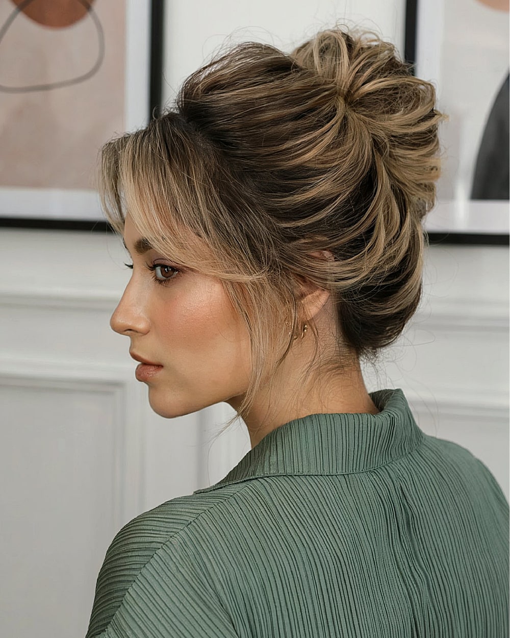 Textured modern French twist updo with tousled volume for thick highlighted hair
