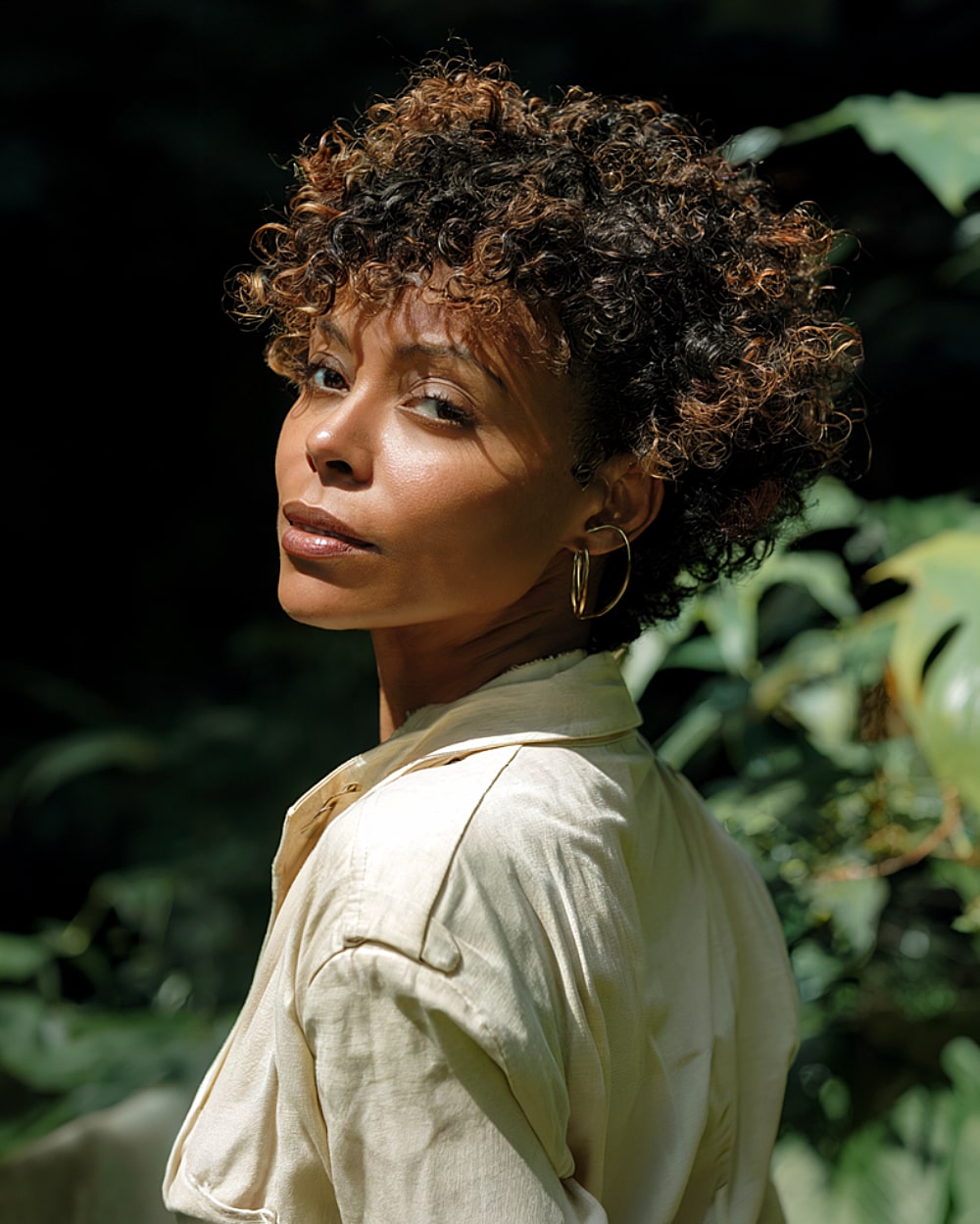 Curly pixie bob with rounded shape and caramel highlights for Black women over 40