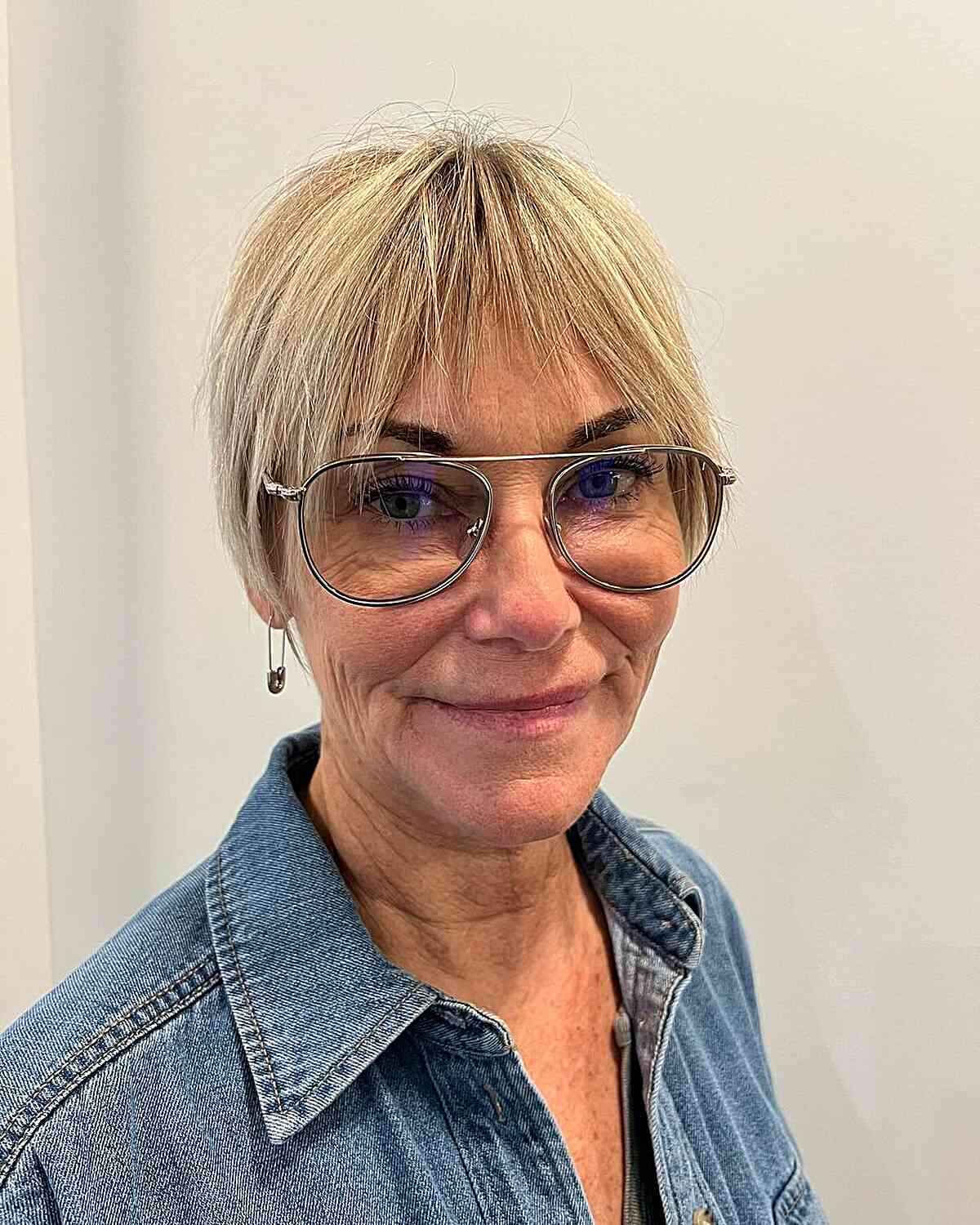 Blonde Pixie Haircut with French Bangs for Women in Their 50s with Glasses