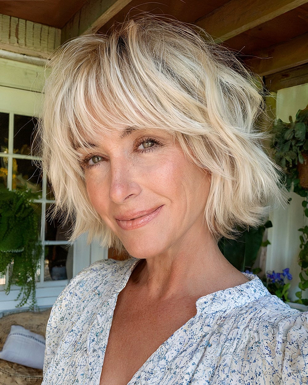 Short shaggy bob with bangs and textured layers for voluminous hair in women over 50