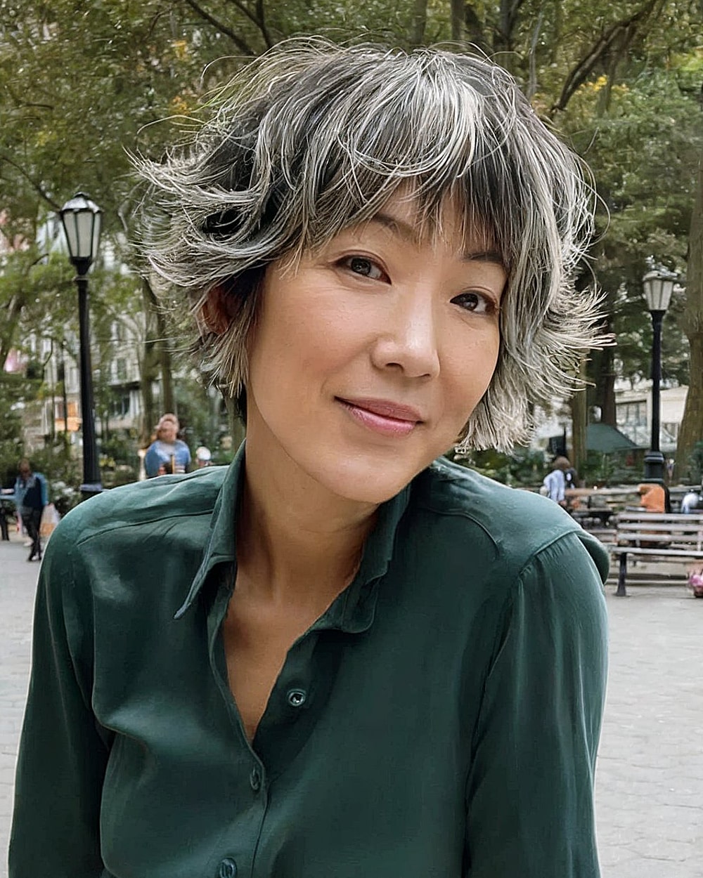 Shaggy pixie bob haircut with flared ends and salt-and-pepper tones for women over 40