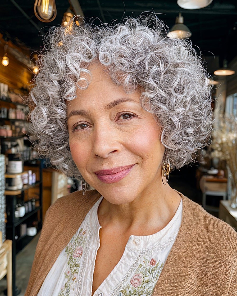 Short stacked curly bob for older women with silver curls and a soft fringe