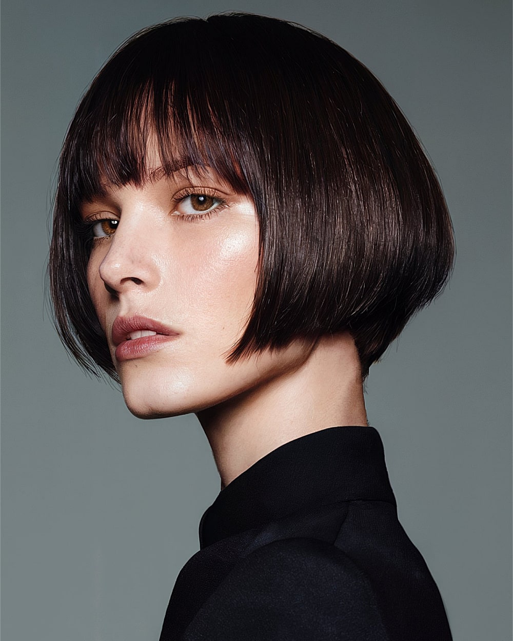 Blunt pinch bob with baby bangs and rounded edges on thick, straight dark hair