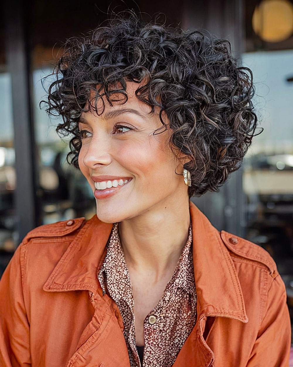 Short stacked curly bob haircut with tight ringlets and voluminous crown for thick naturally curly hair